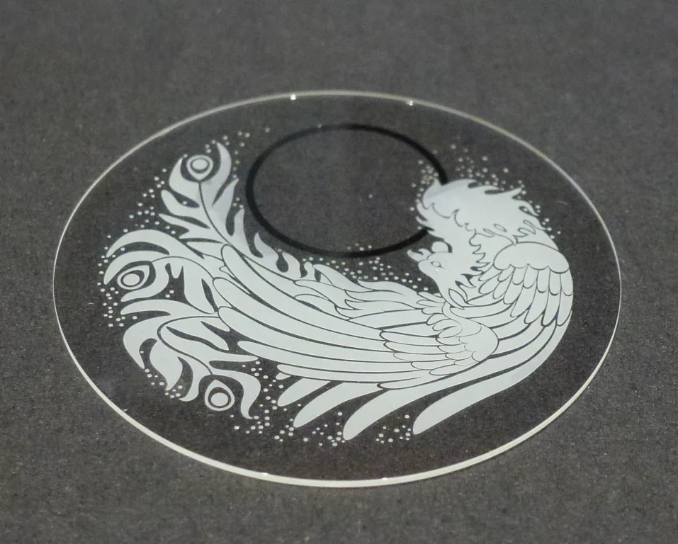 Phénix décoratif obtenu par sablage avec épargne sur un disque transparent